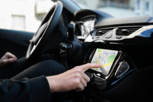A person using touchscreen GPS navigation in their vehicle