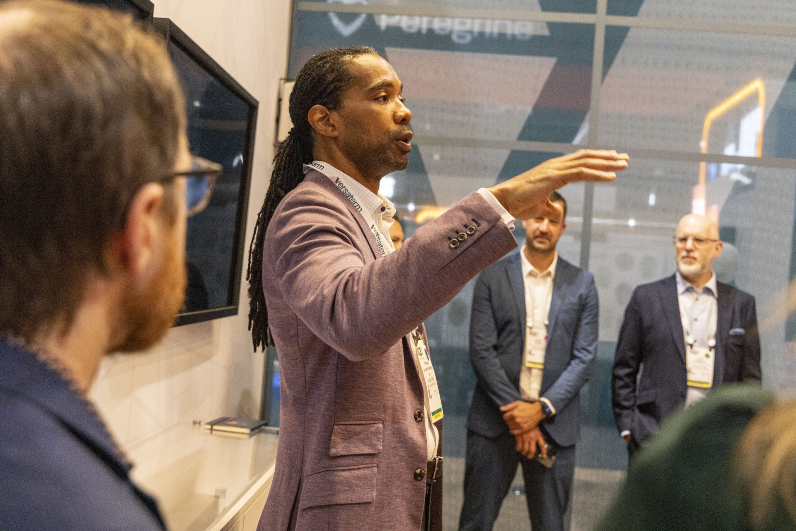 A Versaterm team member gestures while explaining a solution to colleagues at an IACP conference booth.