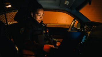 A female police officer using MDT software in her patrol vehicle