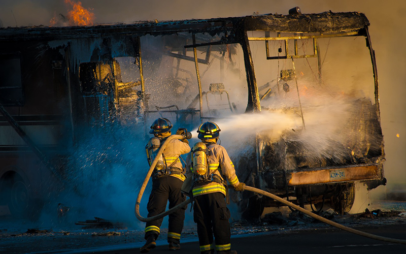 Firefighters hosing down a bus