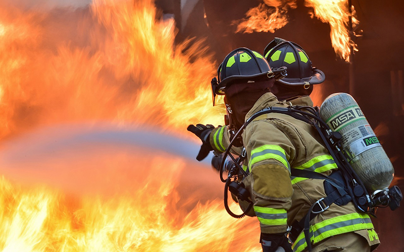 Two firefighters putting out a fire